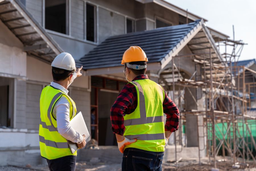 Two men in hard hats inspecting a house build